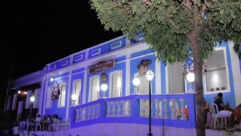 Fachada iluminada da Casa da Cultura Iôzinho Costa, em Correntina, durante evento noturno, com destaque para a arquitetura histórica e decoração cultural.