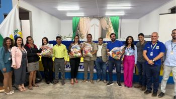 Autoridades municipais, equipe da Secretaria de Educação e coordenadores do EJAI posam para foto durante a entrega de cestas básicas aos estudantes, em evento realizado no auditório da Prefeitura de Correntina.