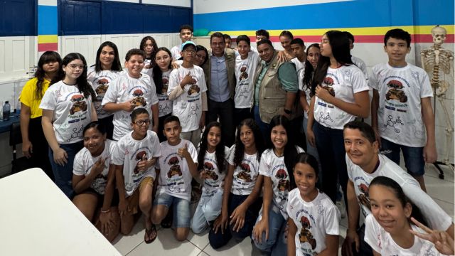 Estudantes do Clube de Ciências Gênius, da Escola Anísia, posam para foto ao lado do prefeito Mariano Correntina, do secretário de Educação Clériston Mota e de professores, exibindo com entusiasmo os novos uniformes entregues pela Prefeitura.