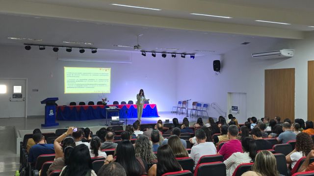 Auditório com participantes acompanhando uma capacitação promovida pela Prefeitura de Correntina. O encontro acontece em um espaço amplo, com apresentação projetada em telão e palestrante à frente do público. A formação reúne profissionais da educação para orientações sobre gestão e prestação de contas do PDDE.