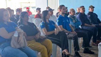 Pessoas participam de reunião de capacitação, com agentes da Guarda Civil Municipal e servidores sentados em cadeiras no local do evento.