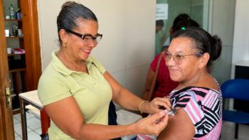Profissional de saúde aplica vacina no braço de uma mulher durante atendimento em uma unidade de saúde de Correntina.