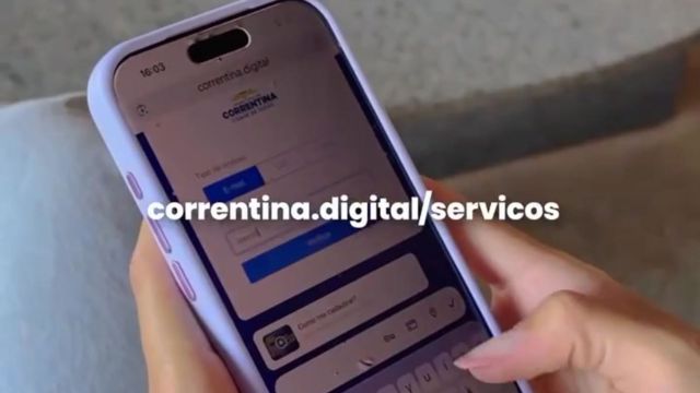 Mulher segurando um smartphone com a inscrição “correntina.digital/servicos” exibida na imagem, representando acesso digital a serviços da Prefeitura de Correntina.