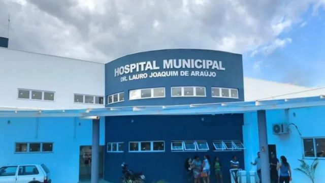 Fachada do Hospital Municipal Dr. Lauro Joaquim de Araújo, em Correntina, com a identificação do hospital na parte superior do prédio e algumas pessoas na entrada da unidade.