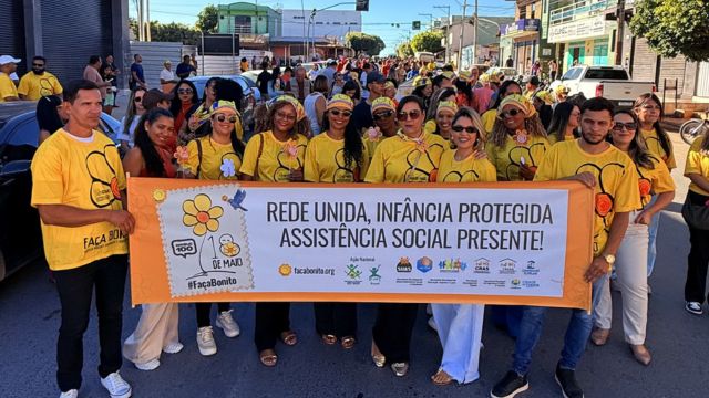 Participantes da caminhada da campanha Faça Bonito durante mobilização em Correntina, com faixa de conscientização sobre o combate ao abuso e à exploração sexual de crianças e adolescentes.