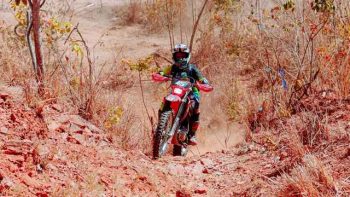 Piloto participa de trilha de motocicleta em trecho de estrada de terra durante o Trilhão da Independência em Correntina.